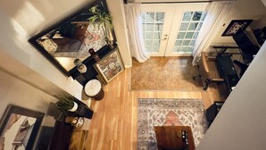 Un amplio salón con techo alto, un ventanal y vistas al exterior.