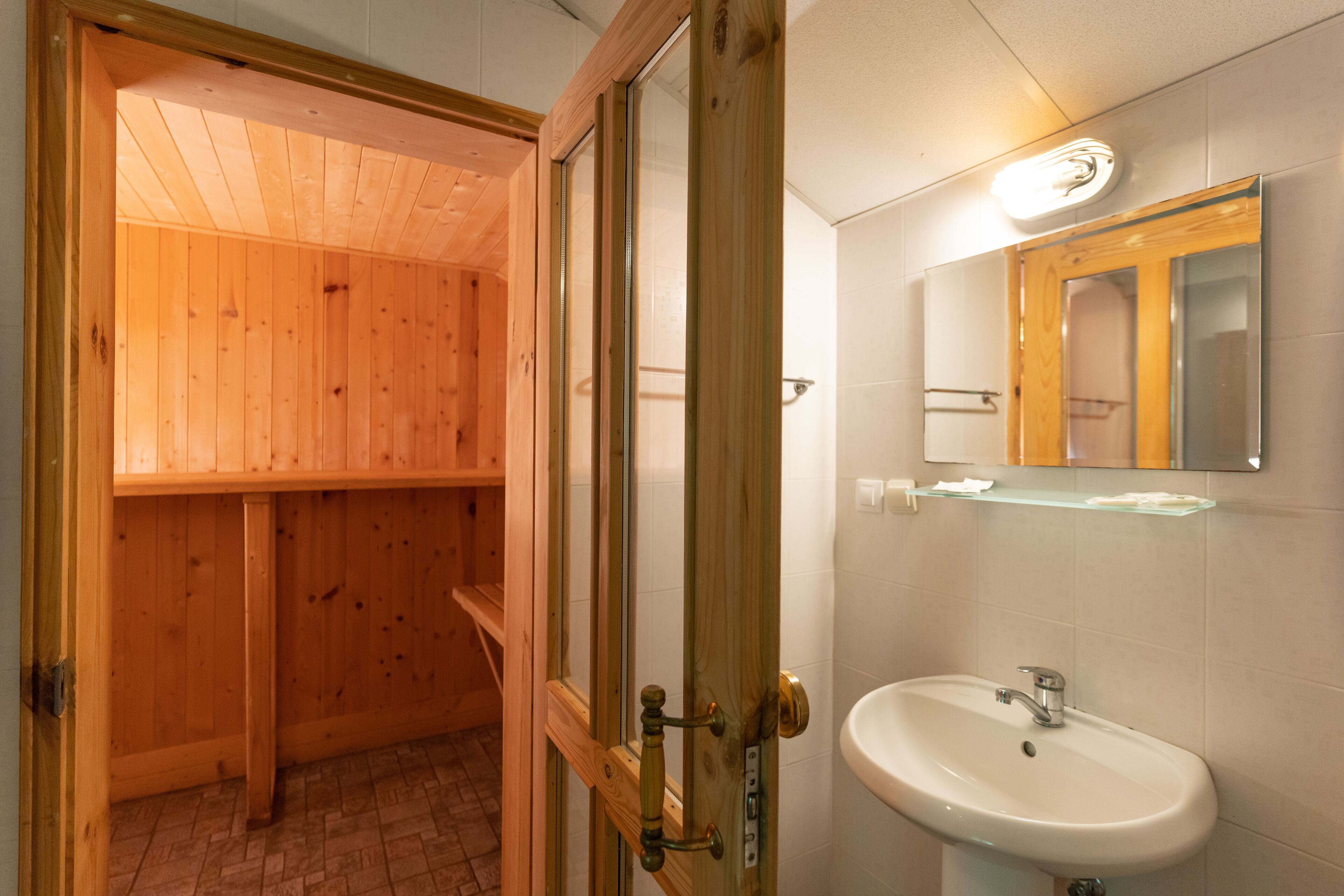 A wooden interior with a white sink and mirror.