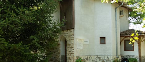 A rustic building with a stone facade, a wooden door, and a small window.