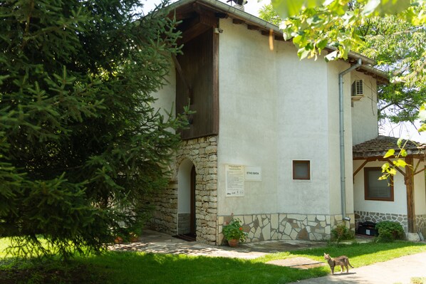 Un edificio rústico con fachada de piedra, puerta de madera y una ventana pequeña.