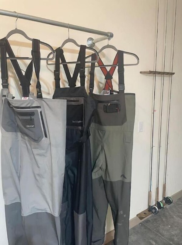 A rack of outdoor work pants in various colors and styles.