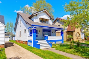 Situated in a charming neighborhood, this house features a welcoming front porch and a well-manicured lawn.