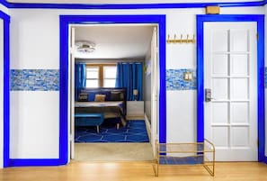 Relax in this stylish room with a comfortable bed, bedside table, and wall-mounted shelf.