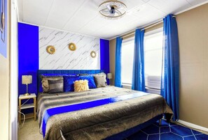 Relax in a stylish room with a large bed, two nightstands, and a unique ceiling design.