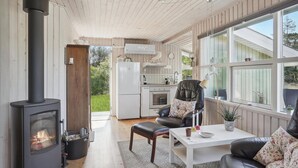 Ein gemütliches Wohnzimmer mit Kamin, Essbereich und Küche.