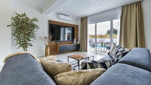 A modern living room with a flat-screen TV, a large plant, a chessboard, and a balcony with a pool. - Beach front home in Bibinje (Bibinje)