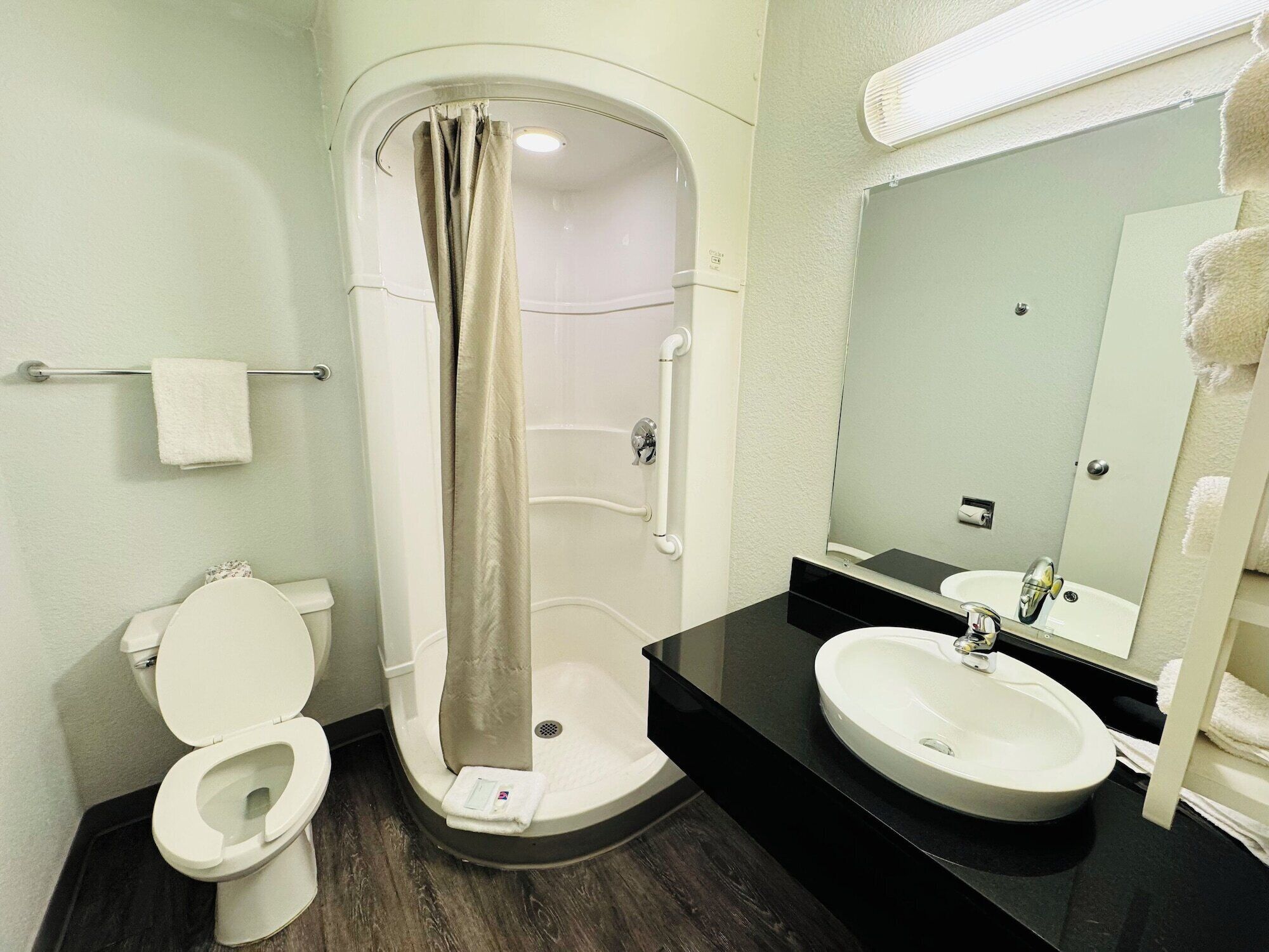 A modern bathroom with a shower, toilet, and two sinks.