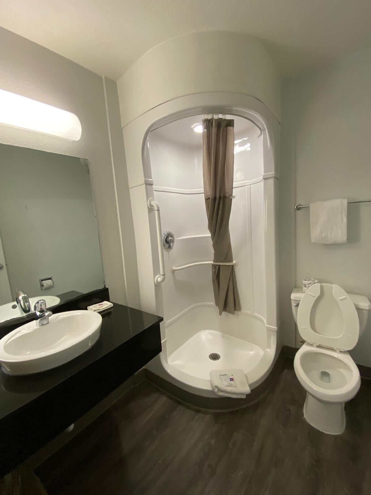 Une salle de bain moderne avec une douche à parois incurvées, un lavabo et des toilettes.