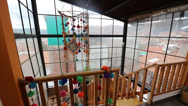 A wooden staircase with colorful pom-poms and a hanging decoration. - PRIVATE APART WITH A COZY TERRACE (Cusco)