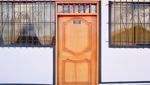 A wooden door with a number plate, flanked by two windows with metal bars. - PRIVATE APART WITH A COZY TERRACE (Cusco)