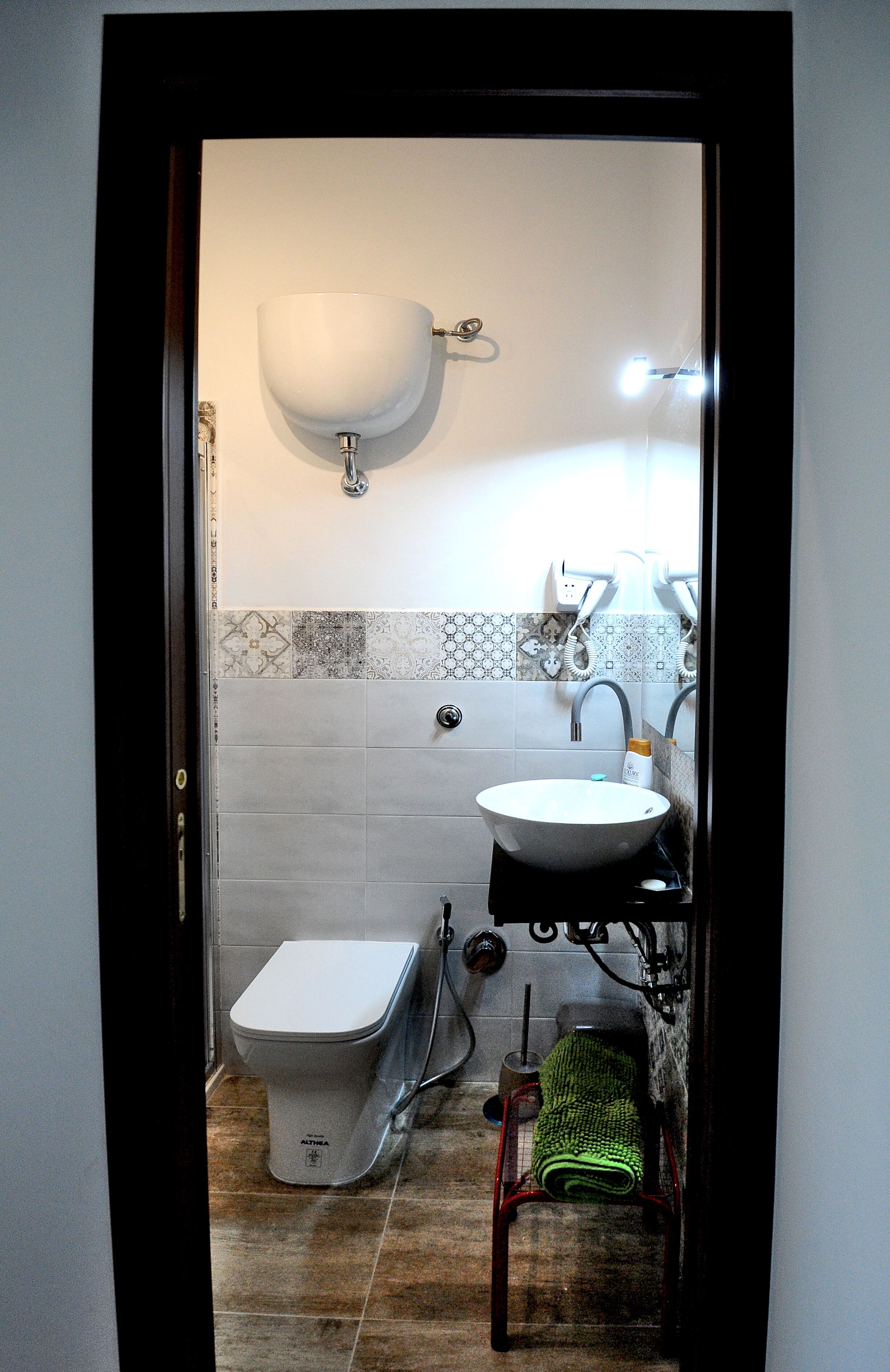 A compact bathroom with a toilet, sink, and shower.