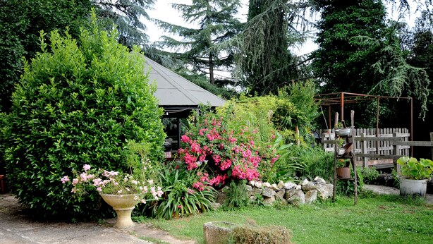 A garden with a stone pathway, a wooden pergola, and various plants and flowers. - ANCIENT FARMHOUSE SURROUNDED BY GREENERY (Sezze)