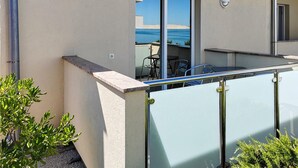 A modern building with a balcony overlooking a body of water. - Cozy apartment in Rtina with WiFi (Rtina)