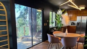 Una cocina moderna con comedor, ventanas amplias y suelo de madera en espiga.