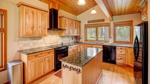 Una cocina amplia con armarios de madera, encimeras de granito y una isla grande.