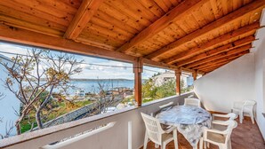 A covered outdoor area with a table and chairs, overlooking a body of water and a hilly landscape. - Beautiful apartment in Kustici with WiFi (Kustici)