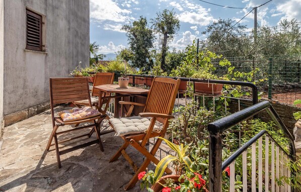 A patio with wooden furniture, a table, and potted plants. - Gorgeous apartment in Rijeka (Rijeka)
