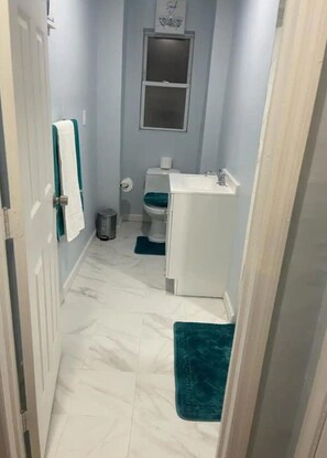 Enter a serene bathroom with a white sink, toilet, and towel.