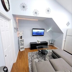 Relax in this stylish living room with a flat-screen TV, entertainment unit, and comfortable sofa.