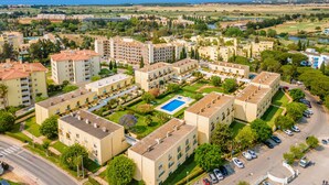 Een woonwijk met appartementencomplexen, een zwembad en uitzicht op zee.