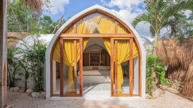 A cozy, semi-open structure with a bed and a view of a pool, surrounded by tropical plants and a clear sky. - Villa Sanah (Tulum)