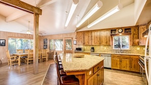 A spacious kitchen with wooden cabinets, a granite countertop, and modern appliances. - Yosemite's Riverfront Retreat (Yosemite National Park)