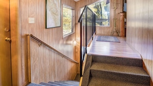 A wooden interior with a staircase, a large window, and a framed map on the wall. - Yosemite's Riverfront Retreat (Yosemite National Park)
