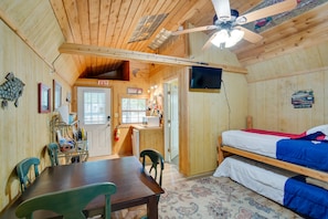 A wooden cabin with a dining area, a kitchenette, a bed, and a ceiling fan. - Emory Studio Cabin w/ Lake Fork Boat Access! (Emory)