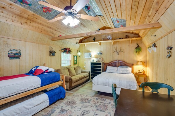 A cozy cabin-style room with bunk beds, a sofa, a dining table, and a ceiling fan. - Emory Studio Cabin w/ Lake Fork Boat Access! (Emory)