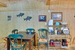 A wooden interior with a dining table, chairs, and a kitchen area with appliances. - Emory Studio Cabin w/ Lake Fork Boat Access! (Emory)