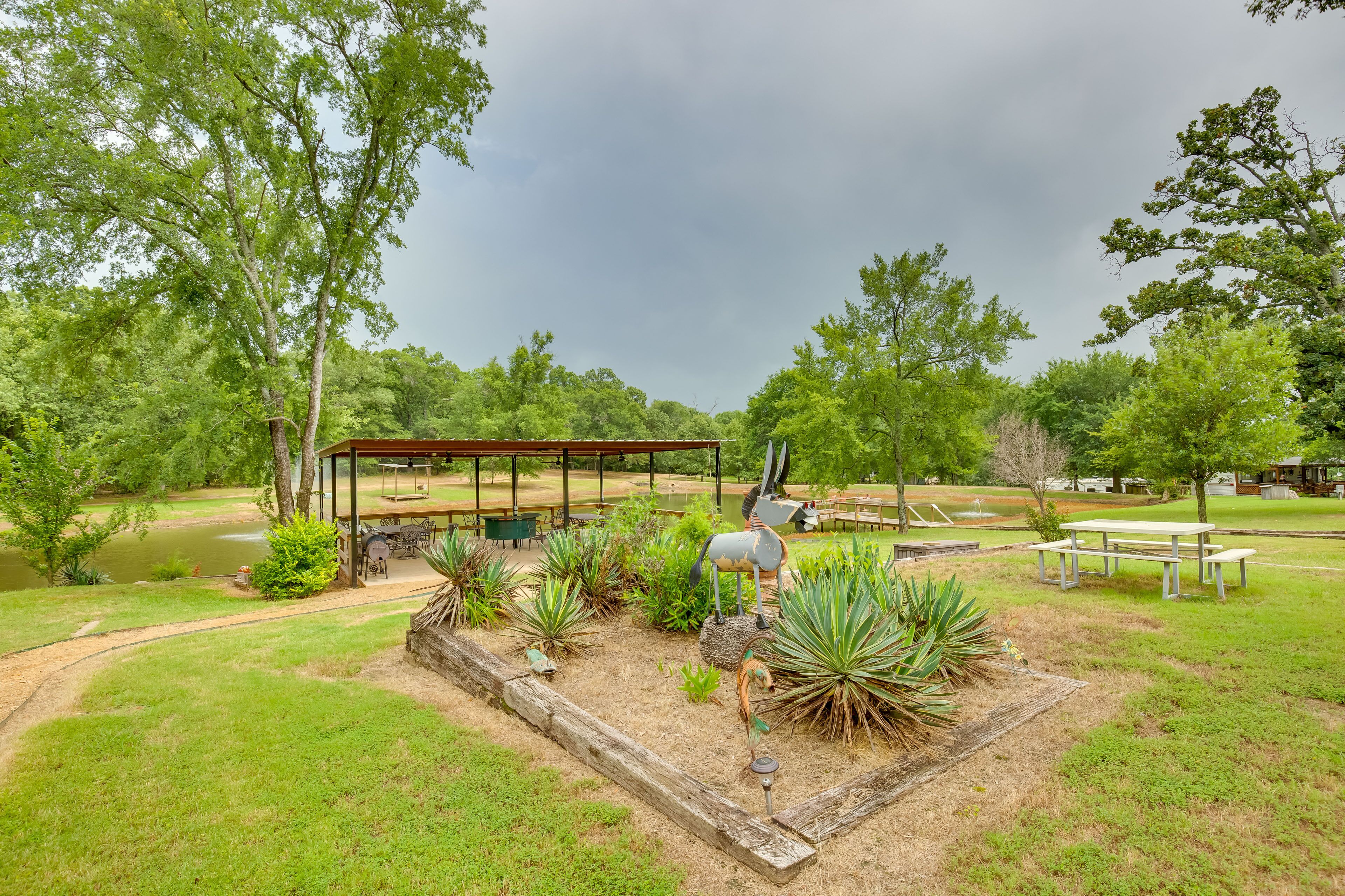 A park with a picnic area, a covered seating area, and a pond.