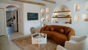 Un soggiorno con divano, tavolino e mensole decorative a parete.