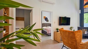 A modern bedroom with a bed, a TV, and a sofa.