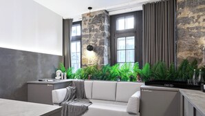 A modern interior with a sofa, a small table, and a kitchen area with a refrigerator.