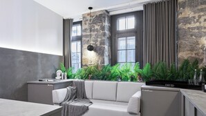 A modern living area with a sofa, a small table, and a kitchen counter. - PREMIUM LOFT | The Signature (Montréal)