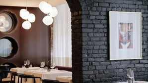 A restaurant interior with a black brick wall, white tables, and hanging spherical lights. - PREMIUM LOFT | The Signature (Montréal)
