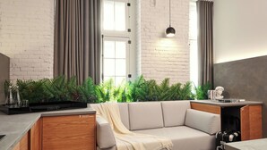 A modern living room with a sofa, a coffee table, and a built-in kitchen area. - LOFT | The Wood Mood (Montréal)