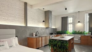 A modern hotel room with a bed, a small kitchen area, a dining table, and a seating area with a sofa. - LOFT | The Wood Mood (Montréal)