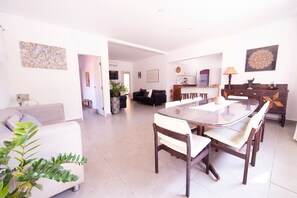 Relax in this stylish living space with a central dining table, comfortable seating, and a cozy sofa.