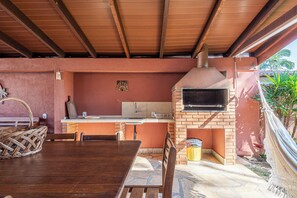 Entertain guests in this outdoor kitchen area with an oven, TV, and dining space.