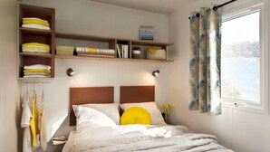 A neatly organized bedroom with a bed, shelves, and a window with curtains. - Gorgeous apartment in Schoonloo (Schoonloo)