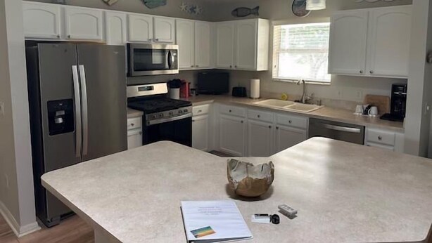 A kitchen with white cabinets, stainless steel appliances, and pendant lighting. - Beautiful 3 bed / 2 bath home near Lake Sumter w/ cart, 2 bikes and wi-fi!   (The Villages)