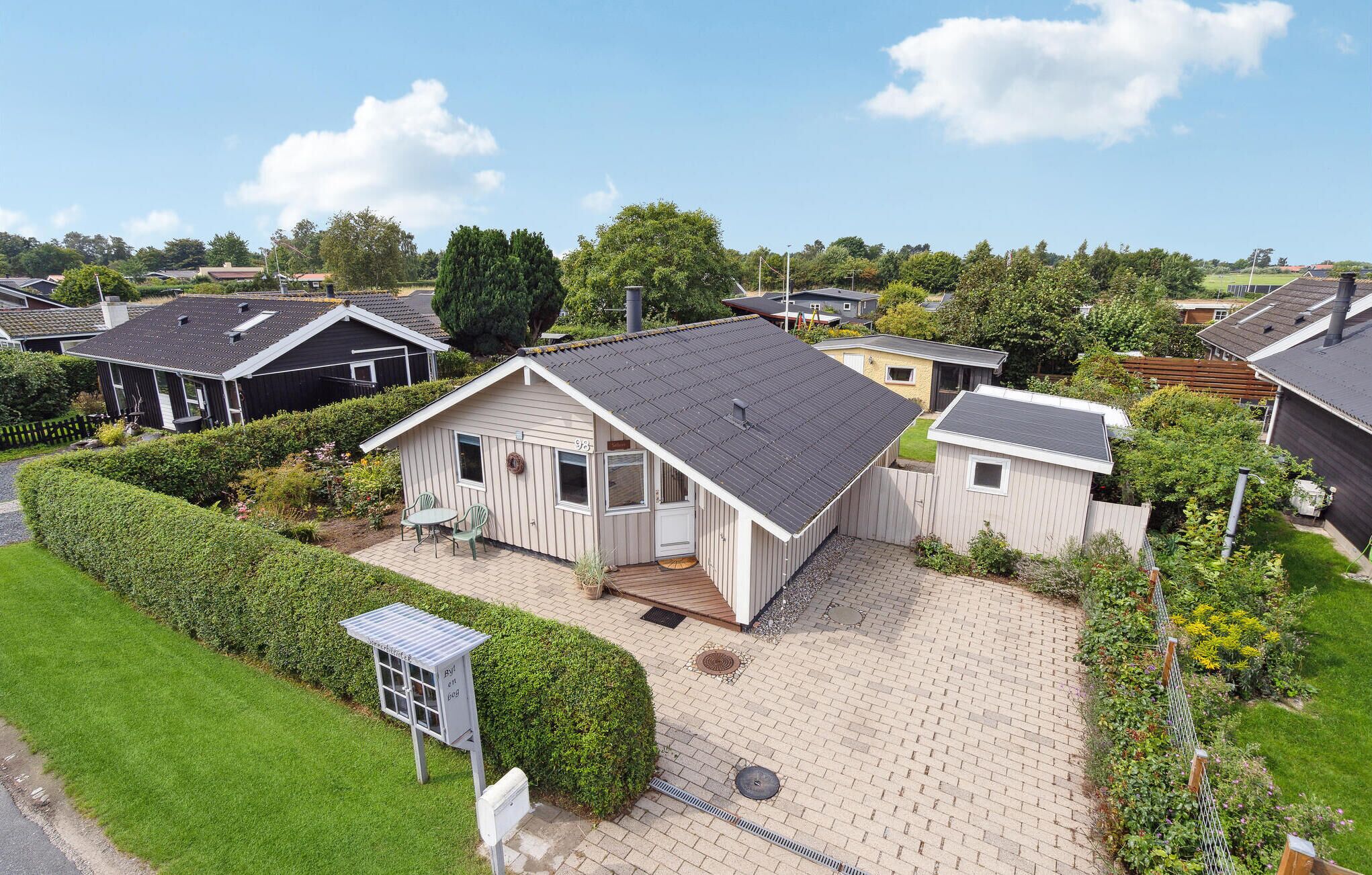 Un quartiere residenziale con diverse case, un vialetto lastricato e una cassetta postale.