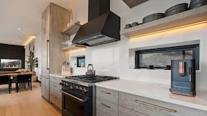 Una cucina moderna con isola centrale, forno a incasso e una grande finestra.