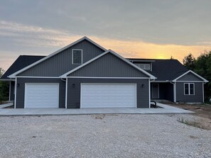A two-story house with a grey exterior and white garage doors. - Excellent location! Newly built spacious family home in Fish Creek, WI (Fish Creek)