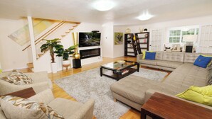 A living room with a sofa, armchairs, a coffee table, a TV, and a fireplace. - Hop, Skip and a Jump: Minutes from the Mountains (Sevierville)