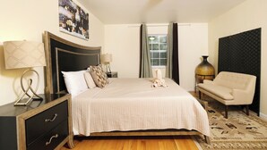 A neatly arranged bedroom with a bed, bedside tables, a chair, and a window with curtains. - Hop, Skip and a Jump: Minutes from the Mountains (Sevierville)