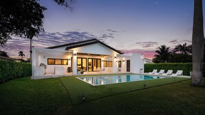 A modern house with a swimming pool, a covered patio, and a well-maintained lawn. - Modern Waterfront Paradise with Heated Pool - Near the Beach & Aventura Mall! (Miami)
