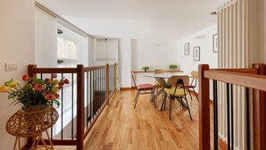 A dining area with a wooden floor, a round table, and chairs. - GuestHost - Cozy apartment in St. Ambrose! (Milano)