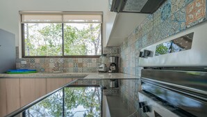 Una cucina con un'ampia finestra, un frullatore, una macchina da caffè e un forno in acciaio inossidabile.